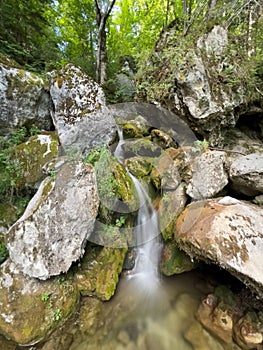 Cascade falls over mossy rocks at the Myrafaelle (myrafalls) hiking trail