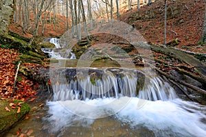 Cascade of mountain river in autumn forest