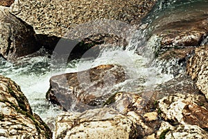 Cascade of a mountain river. Background in warm tones.