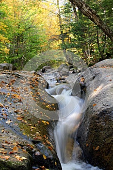 Cascade river flow with fall foliage