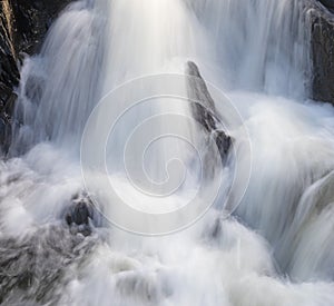 Cascade of water falling over boulders in Maine