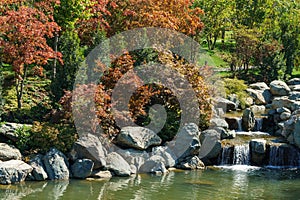 Cascade waterfall on the large lake Oike in Japanese garden. Public landscape park of Krasnodar or Galitsky Park