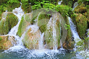 A cascade waterfall among large stones in the Plitvice Lakes Landscape Park, Croatia in spring or summer. Croatian