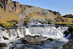 Cascading stream of pristine water flows around large rocks in a peaceful natural setting