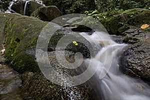 Cascading water stream at Kanching waterfall, located in Malaysia,wet and mossy rock, surrounded by green rain forest