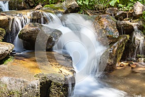 Cascading waterfall closeup very smooth water with wet rocks