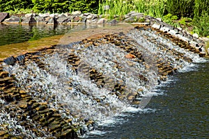 Cascading waterfall of stone in a decorative pond.