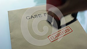 Case files classified, hand stamping seal on folder with important documents