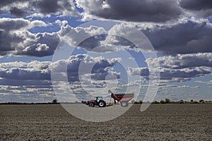 Case IH tractor and an Unverferth grain cart rest in a completely harvested field