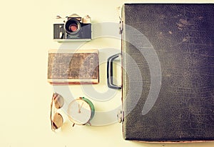 Case with old camera sunglasses and clock. filtered image.