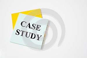 Case study text written on a white notepad with colored pencils and a yellow background