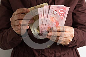 Cash bills from Canadian currency. Dollars. Old retired person paying in cash