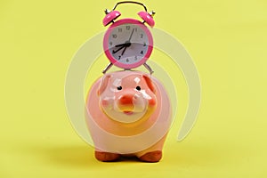 Cash box with financial income. Piggy bank with alarm clock.