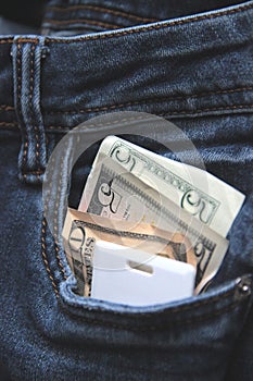 Cash and card key in a pocket of blue jeans close-up. the concept of office workers. blur