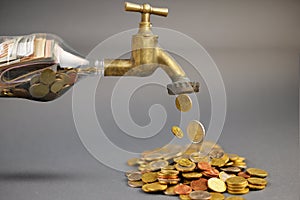 Cash coins falling from a golden faucet, wealth and prosperity concept