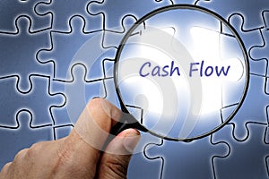 Cash flow word. Magnifier and puzzles. photo