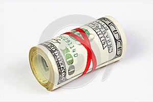 Cash hundred-dollar bills in a roll, tied with a red ribbon.