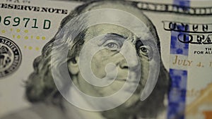 Cash money background. Benjamin Franklin portrait on 100 US dollar bill close up, the image is rotated