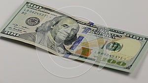 Cash money background. Benjamin Franklin portrait on 100 US dollar bill close up, the image is rotated