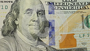 Cash money background. Benjamin Franklin portrait on 100 US dollar bill close up, the image is rotated