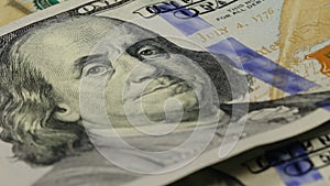 Cash money background. Benjamin Franklin portrait on 100 US dollar bill close up, the image is rotated