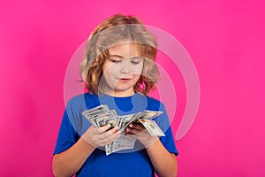 Cash money in dollar banknotes. Kid having a lot of hundred dollars isolated on studio background.