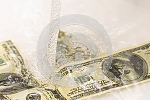 Cash Money Going Down Sink Drain Isolated on White Background