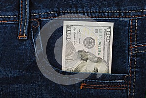 Cash, money is in the pocket of blue jeans.