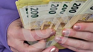 Cash payments in EU countries.Euro currency . Two hundred euro pack in female hands close-up.