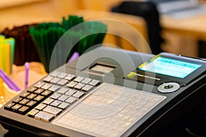 cash register installed on counter for accepting order from customer.sales man entering amount on electronic cash register in