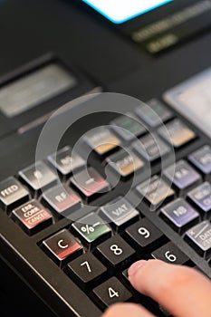 cash register installed on counter for accepting order from customer.sales man entering amount on electronic cash register in