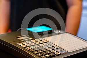 cash register installed on counter for accepting order from customer.sales man entering amount on electronic cash register in