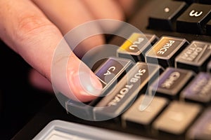 cash register installed on counter for accepting order from customer.sales man entering amount on electronic cash register in