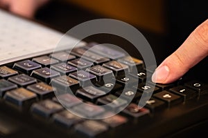 cash register installed on counter for accepting order from customer.sales man entering amount on electronic cash register in