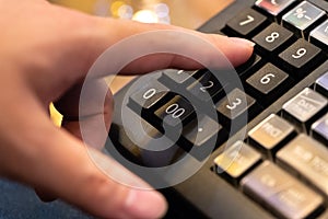 cash register installed on counter for accepting order from customer.sales man entering amount on electronic cash register in