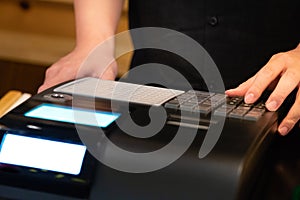 cash register installed on counter for accepting order from customer.sales man entering amount on electronic cash register in