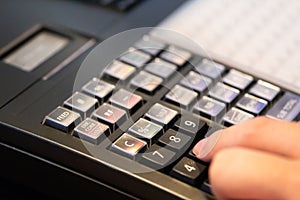 cash register installed on counter for accepting order from customer.sales man entering amount on electronic cash register in