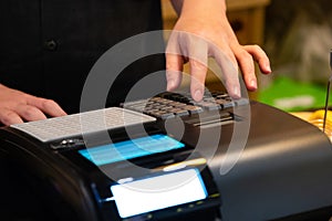 cash register installed on counter for accepting order from customer.sales man entering amount on electronic cash register in