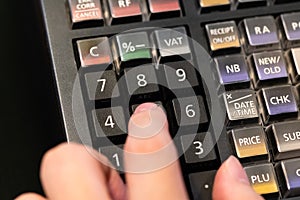 cash register installed on counter for accepting order from customer.sales man entering amount on electronic cash register in