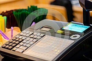 cash register installed on counter for accepting order from customer.sales man entering amount on electronic cash register in