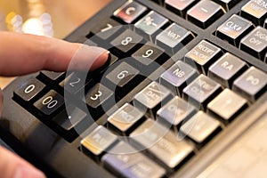 cash register installed on counter for accepting order from customer.sales man entering amount on electronic cash register in