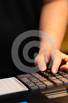 cash register installed on counter for accepting order from customer.sales man entering amount on electronic cash register in