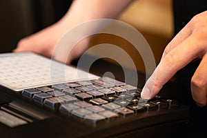 cash register installed on counter for accepting order from customer.sales man entering amount on electronic cash register in