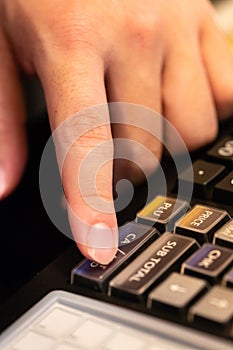 cash register installed on counter for accepting order from customer.sales man entering amount on electronic cash register in