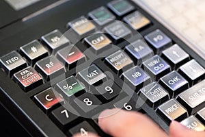 cash register installed on counter for accepting order from customer.sales man entering amount on electronic cash register in