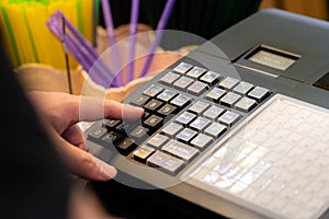 cash register installed on counter for accepting order from customer.sales man entering amount on electronic cash register in