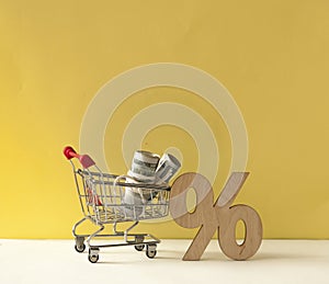 Shopping cart and sign percent on colorful background with copy space. shopping online concept