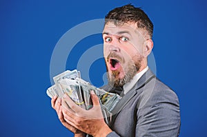 Cash transaction business. Man happy winner rich hold pile of dollar banknotes blue background. Easy cash loans