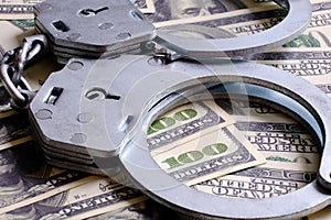 Cash in US Dollars, Real Handcuffs. The Concept of Arrest, Corruption, Bail, Crime, Bribery or Fraud.