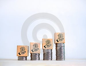 Cashback icon on wood cube blocks on coin stack growth graph steps on white background with space.